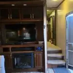 fireplace TV and staircase leading up to bedroom