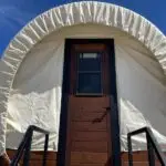 Exter entrance view of covered wagon. Blue sky day.