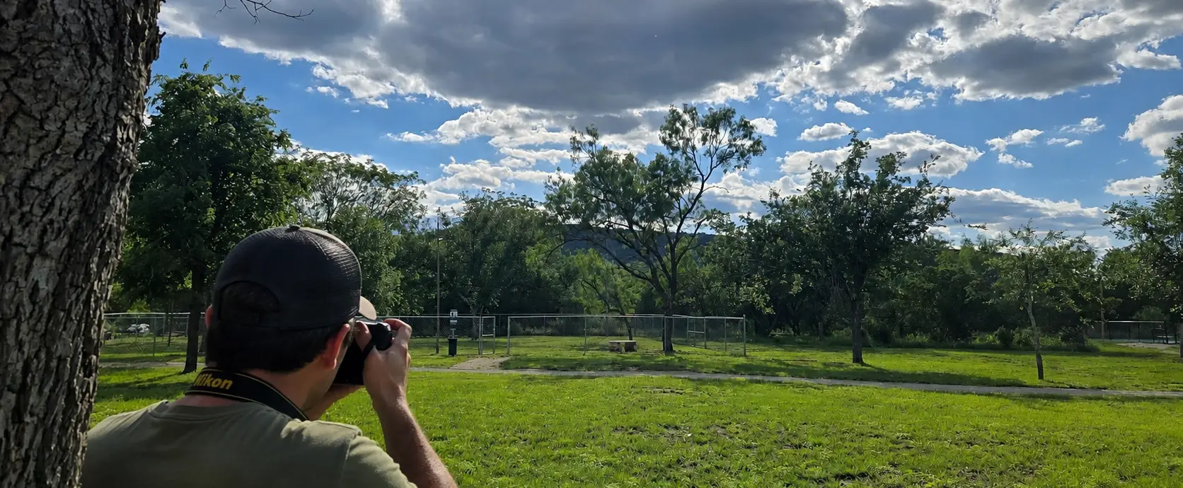 Guest photographing the scenic grounds and Texas Hill Country landscape at Pitmaster RV Park in Concan, Texas