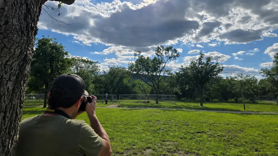 Guest photographing the scenic grounds and Texas Hill Country landscape at Pitmaster RV Park in Concan, Texas