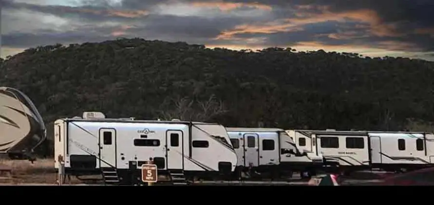 Rental RV accommodations at Pitmaster RV Park in Concan, Texas with scenic Texas Hill Country views at sunset.