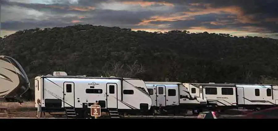 Rental RV accommodations at Pitmaster RV Park in Concan, Texas with scenic Texas Hill Country views at sunset.