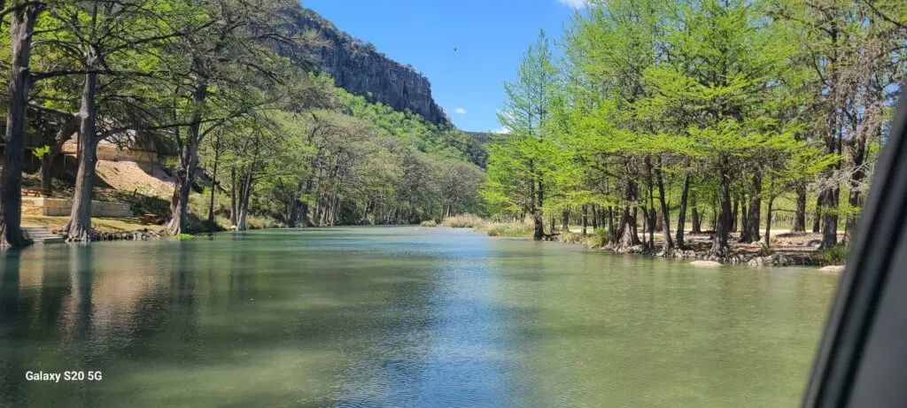 Crystal-clear Frio River at Magers Crossing in Concan, Texas surrounded by cypress trees and Texas Hill Country cliffs.