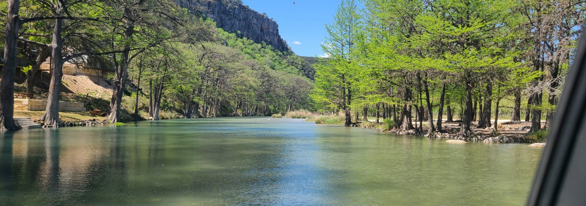Crystal-clear Frio River at Magers Crossing in Concan, Texas surrounded by cypress trees and Texas Hill Country cliffs.